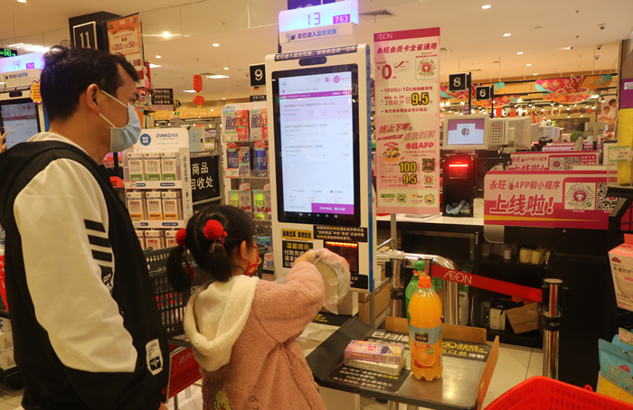 永旺超市使用自助收银机的小女孩.jpg